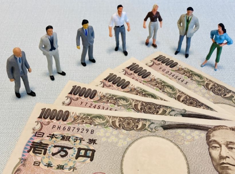 5枚の1万円札と7人のビジネスマンの人形