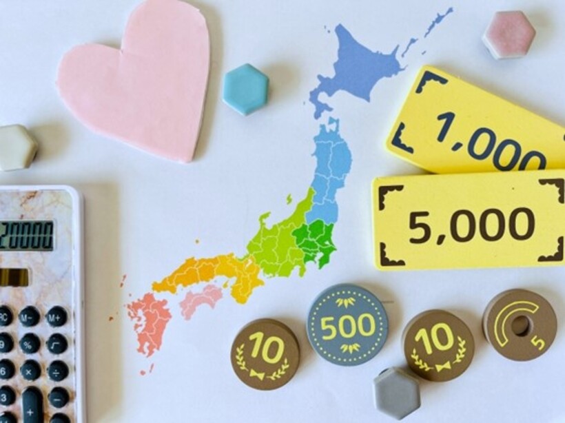 カラフルな日本列島の地図と電卓とおもちゃのお金