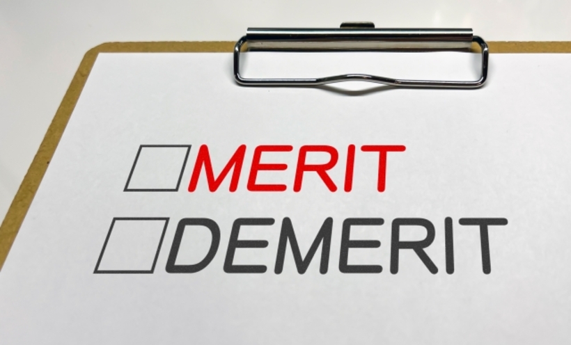 紙に赤字でMERIT、黒字でDEMERITと書かれている